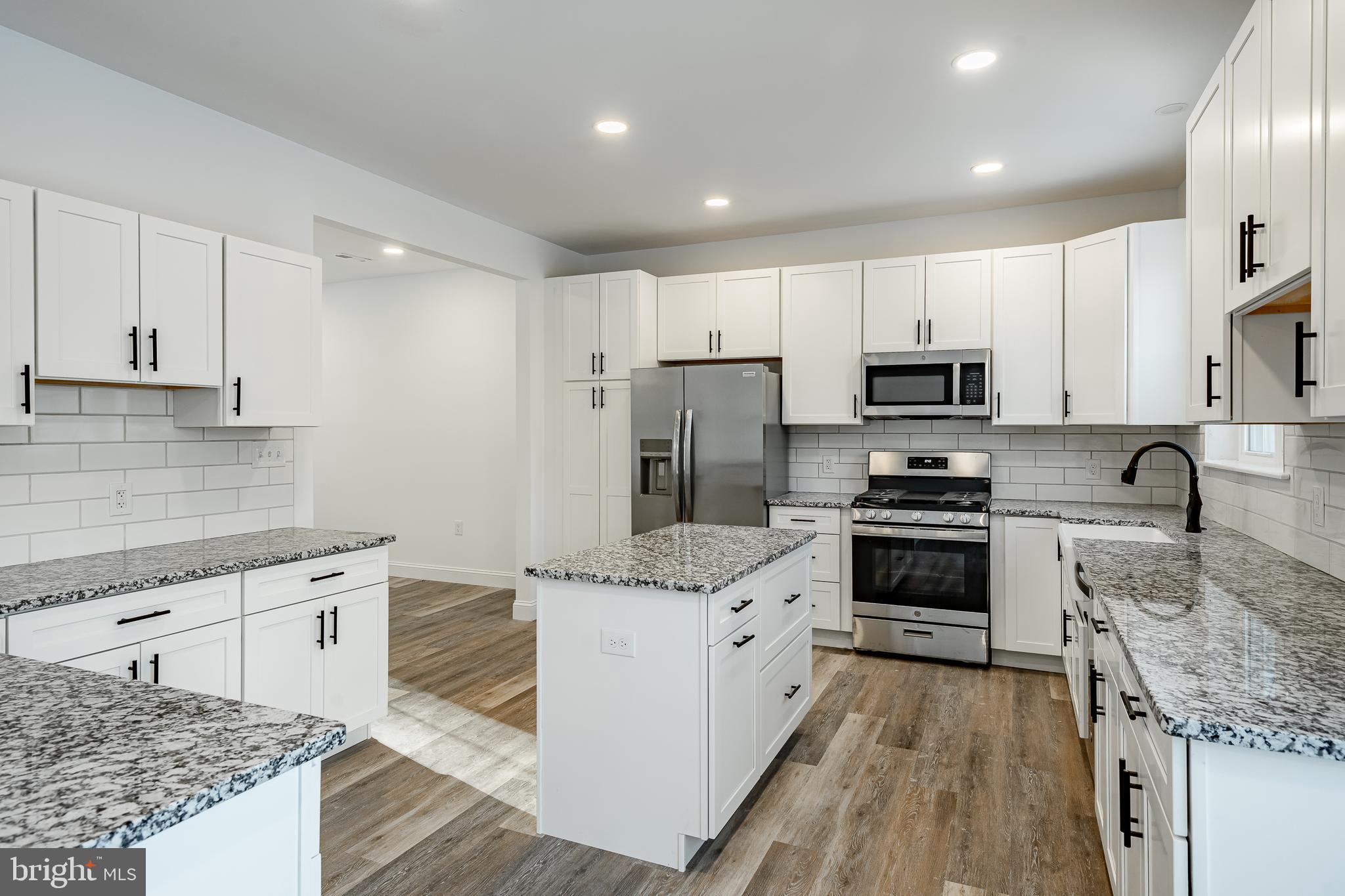 1150 Church Lane Road Reading, PA 19606 - Photo 8 of 45 a kitchen with stainless steel appliances granite countertop a stove top oven a refrigerator a sink and dishwasher with wooden floor
