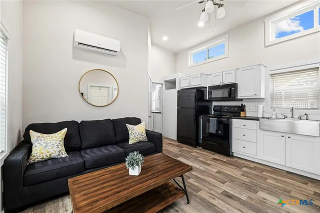 a living room with furniture and kitchen view