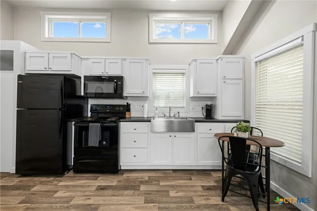 a kitchen with stainless steel appliances kitchen island granite countertop a refrigerator and a stove top oven