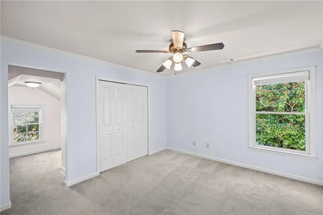 an empty room with windows and fan