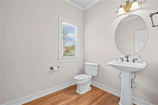 a bathroom with a toilet a sink and mirror
