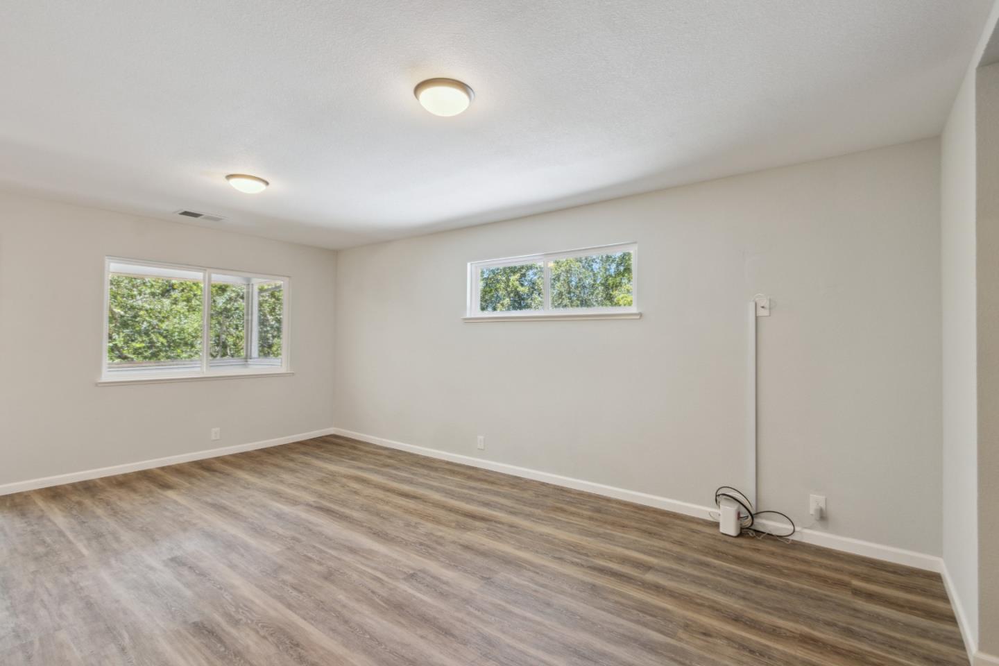 24895 Skyland Road Los Gatos, CA 95033 - Photo 6 of 113 an empty room with wooden floor and windows
