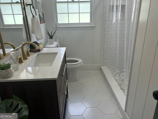 a bathroom with a sink a toilet and a window