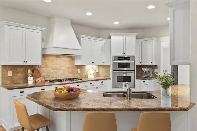 a kitchen with stainless steel appliances granite countertop a refrigerator and a stove