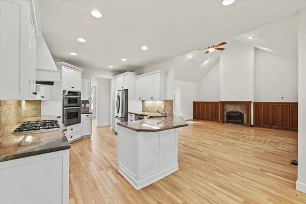 a kitchen with stainless steel appliances granite countertop a refrigerator and a stove