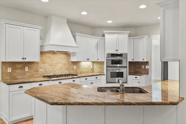 a kitchen with granite countertop a sink a window and stainless steel appliances