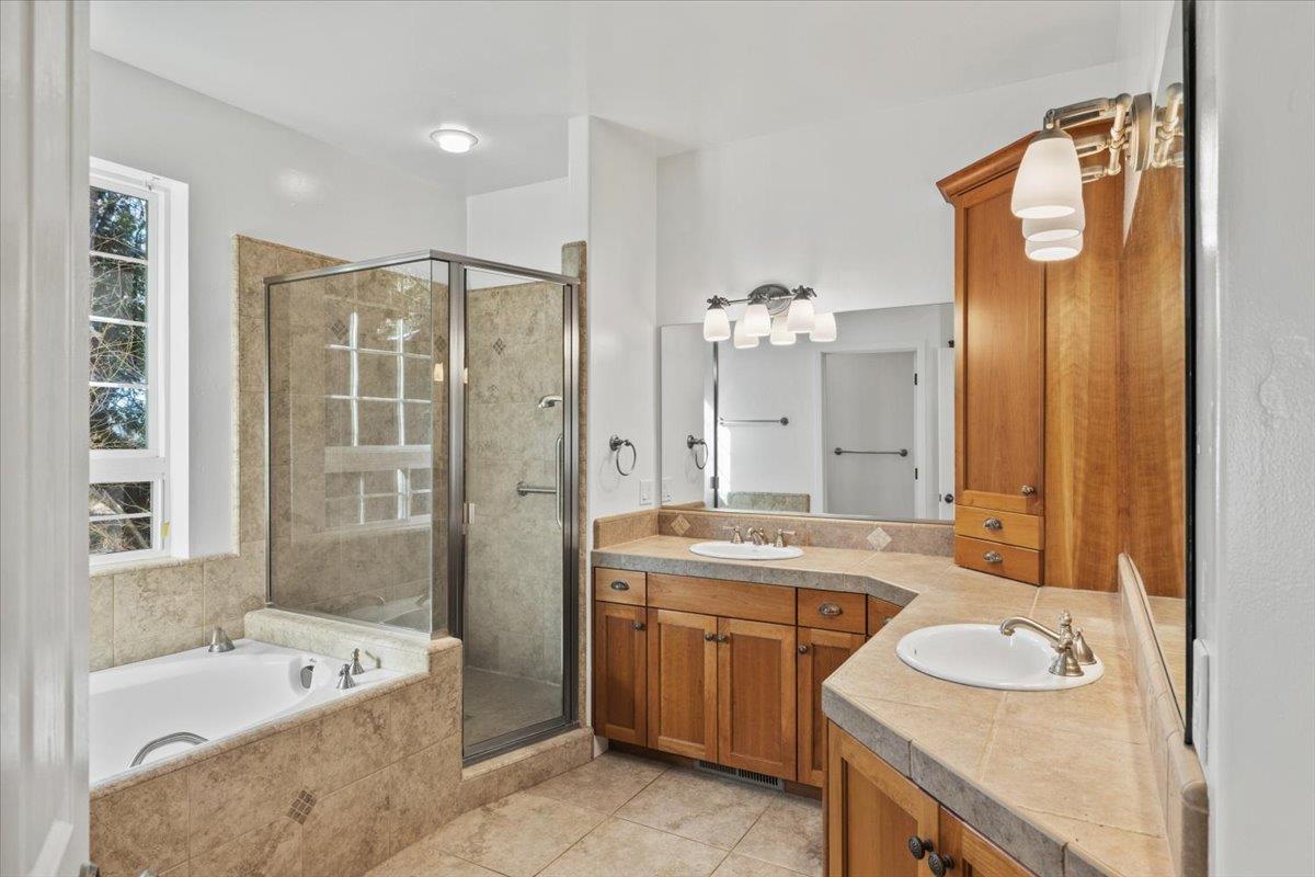 14622 Banner Lava Cap Road Nevada City, CA 95959 - Photo 33 of 66 a bathroom with a sink double vanity granite tub shower and a mirror