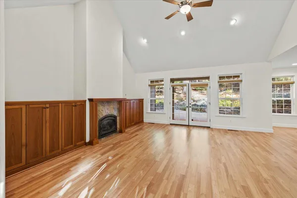a view of kitchen and empty room with wooden floor