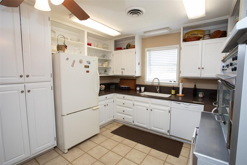 914 Fairview Street Graham, TX 76450 - Photo 5 of 17 a kitchen with stainless steel appliances a refrigerator sink and cabinets