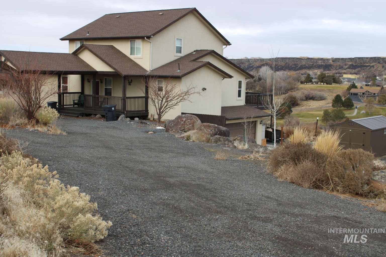View of front of home featuring stucco siding, driveway, a shingled roof, and an attached garage