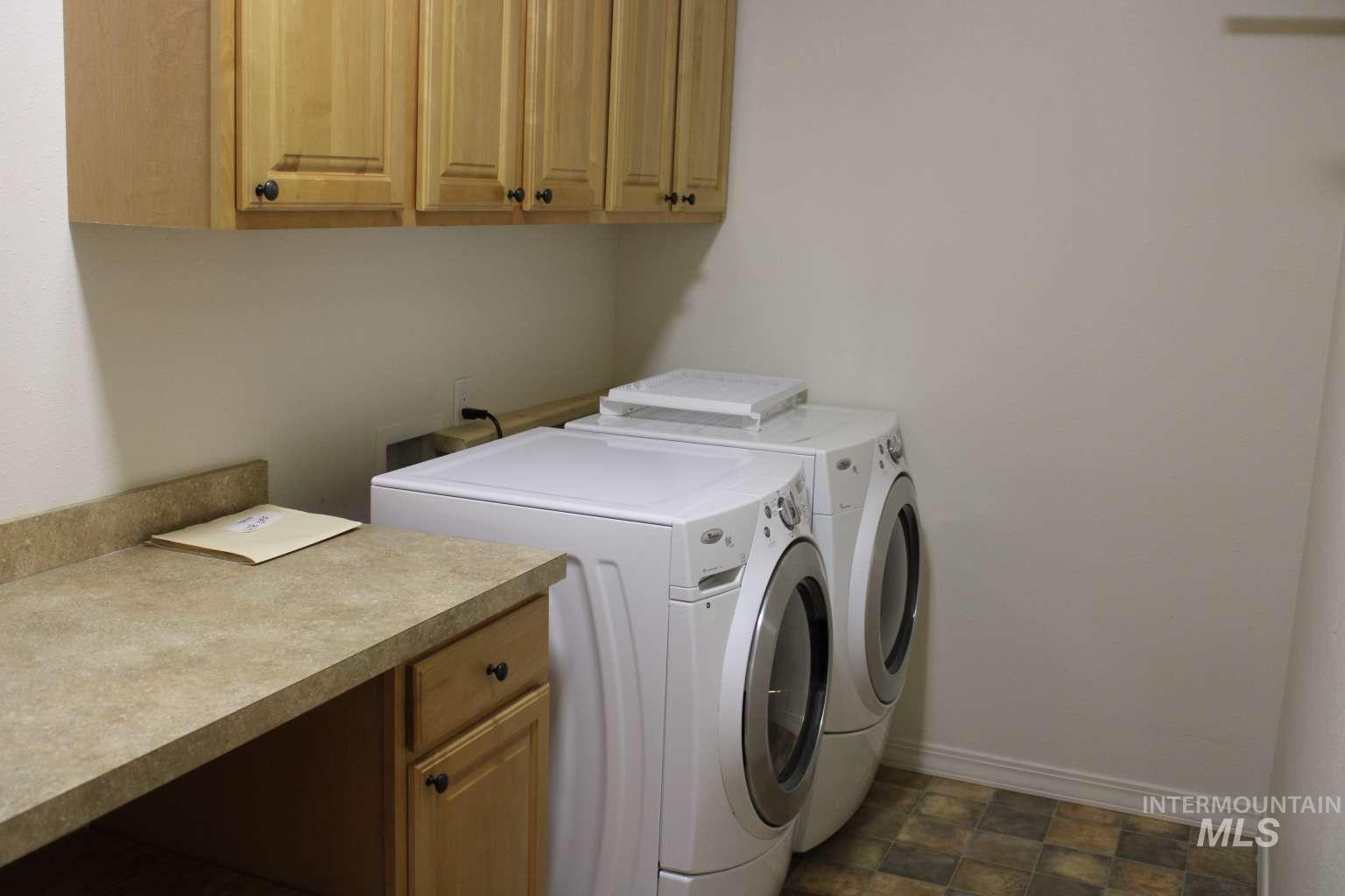 1422 River View Lane Buhl, ID 83316 - Photo 19 of 43 Laundry area featuring washing machine and clothes dryer, cabinet space, and stone finish floors