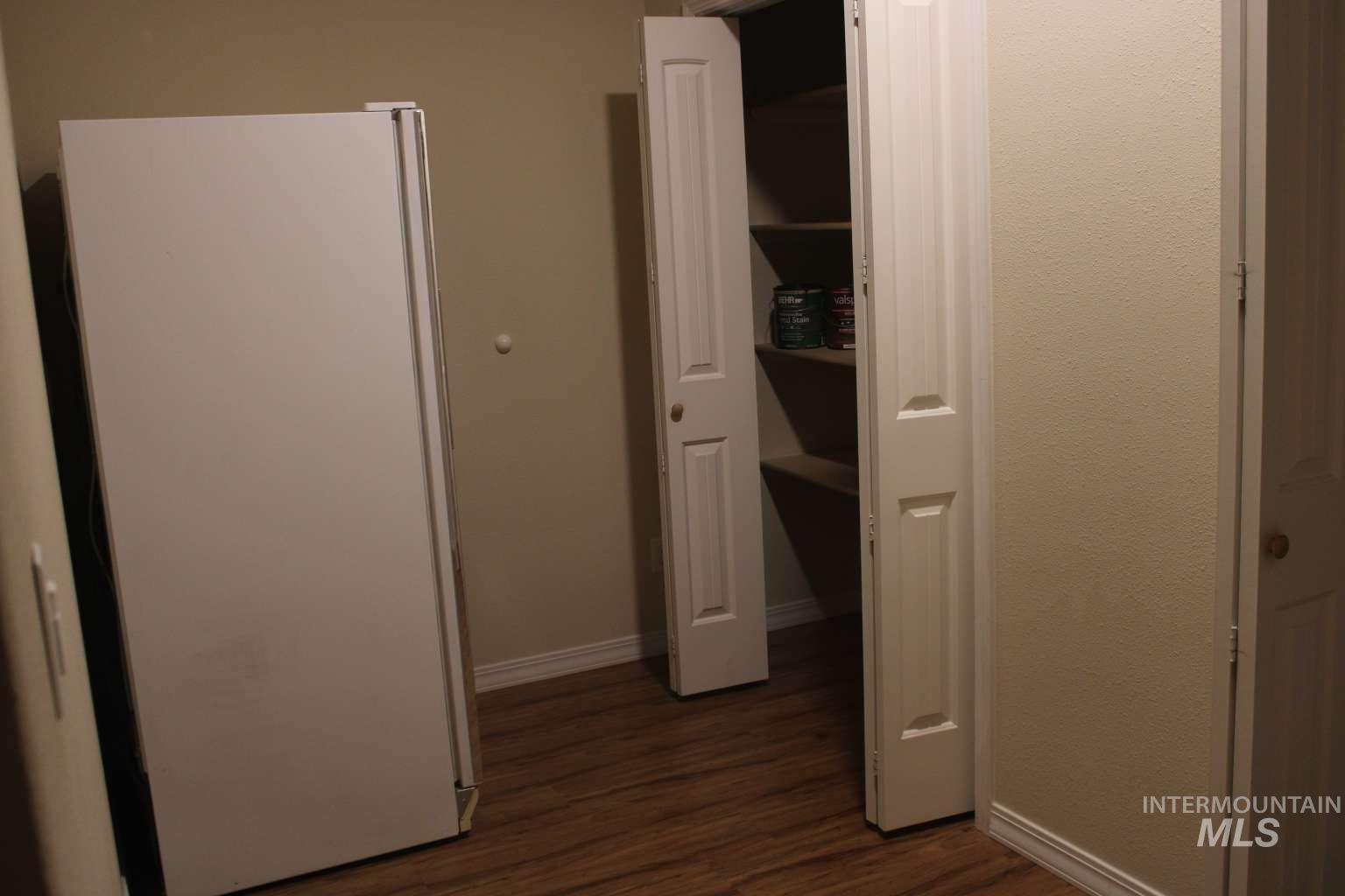 1422 River View Lane Buhl, ID 83316 - Photo 29 of 43 Unfurnished bedroom featuring freestanding refrigerator, dark wood-type flooring, and a closet