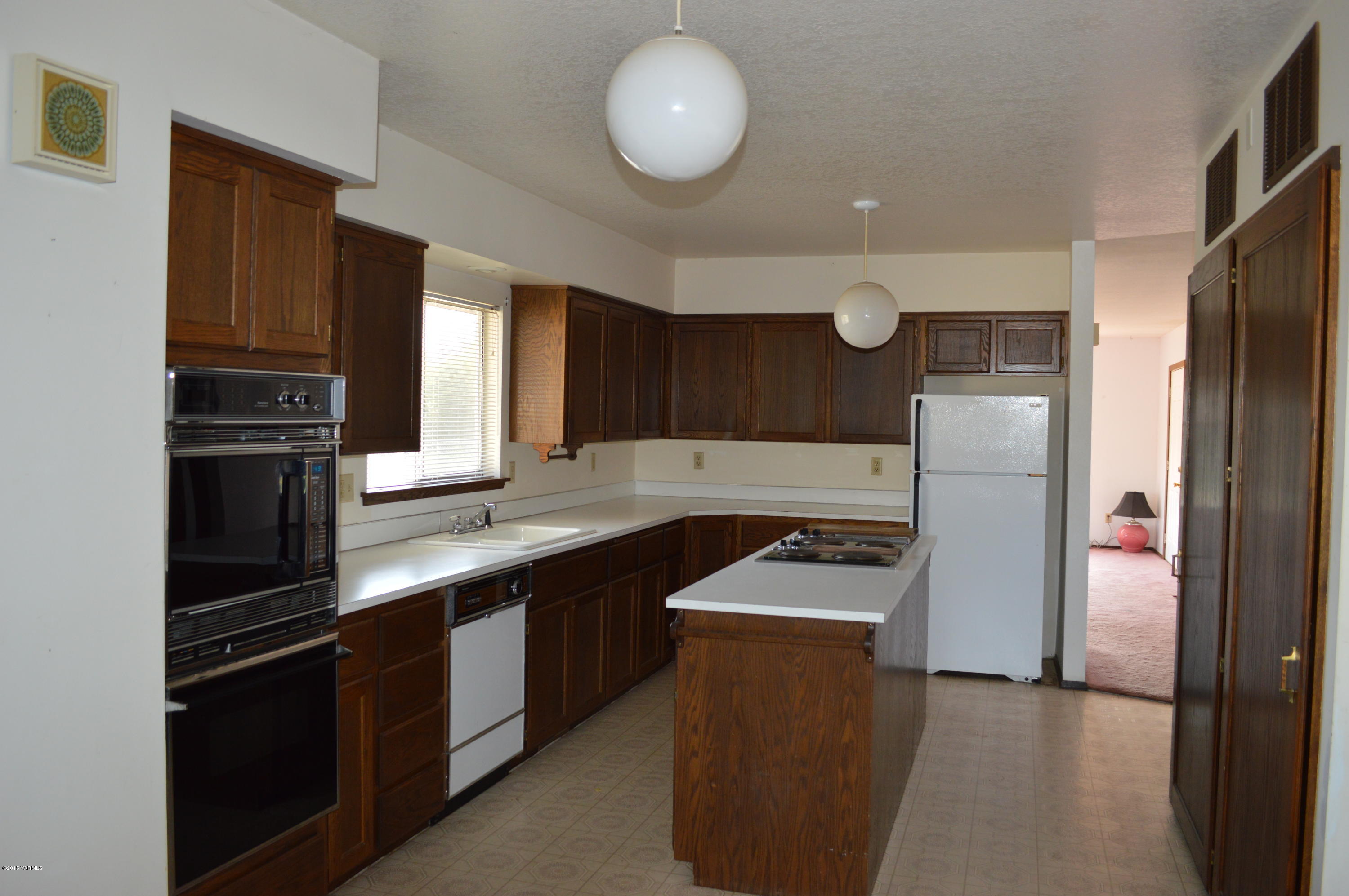 220 Martin Road Toppenish, WA 98948 - Photo 4 of 12 a kitchen with granite countertop a refrigerator a sink and dishwasher