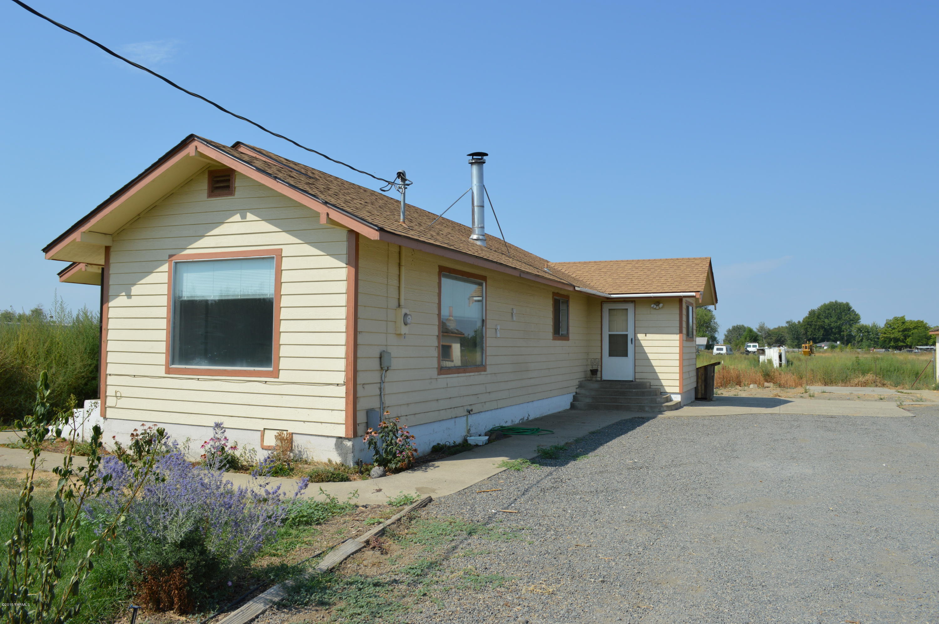 220 Martin Road Toppenish, WA 98948 - Photo 9 of 12 a view of a house with a yard and garage