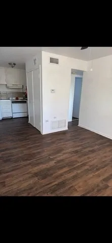 a view of empty room with wooden floor