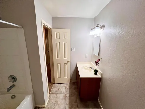 a bathroom with a sink a tub and a mirror