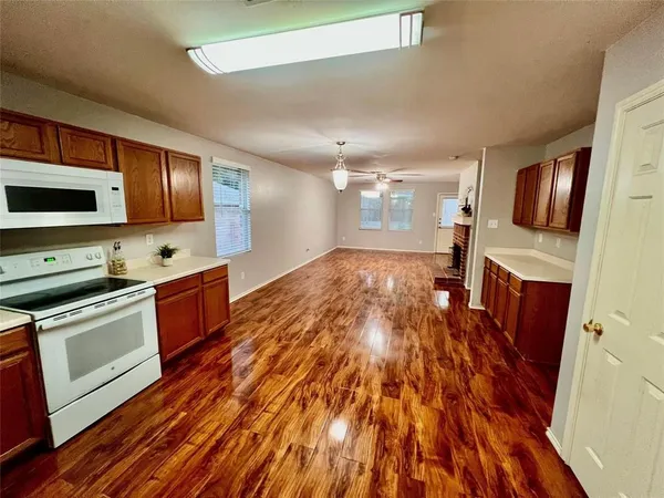 a large kitchen with stainless steel appliances granite countertop a stove and a wooden floors