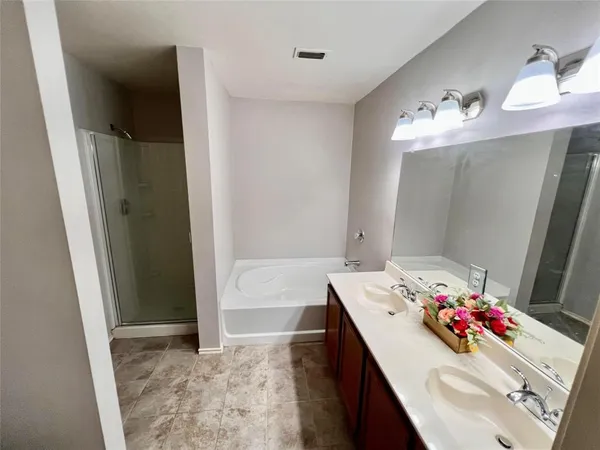 a bathroom with a sink vanity tub and shower