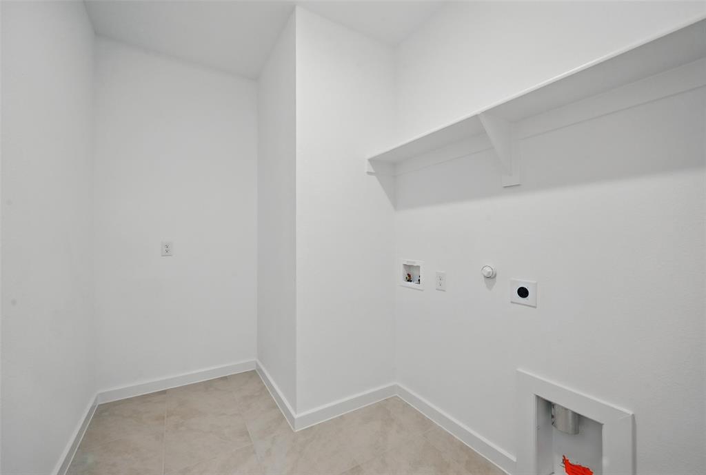 1413 Richardson Street Howe, TX 75459 - Photo 14 of 30 Dedicated utility space featuring a wall-mounted shelf, light-toned tile flooring, and white baseboards