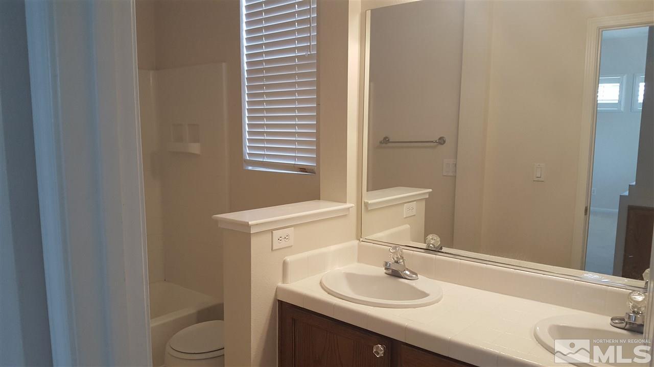 10281 Wolf Ridge Way Reno, NV 89521 - Photo 15 of 22 a bathroom with a granite countertop sink toilet and mirror