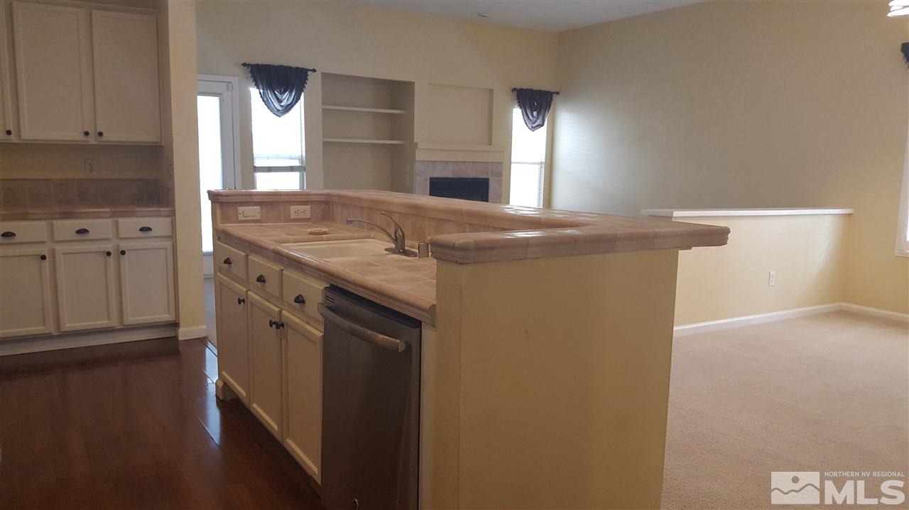 10281 Wolf Ridge Way Reno, NV 89521 - Photo 4 of 22 a kitchen with stainless steel appliances granite countertop a stove a sink and a refrigerator