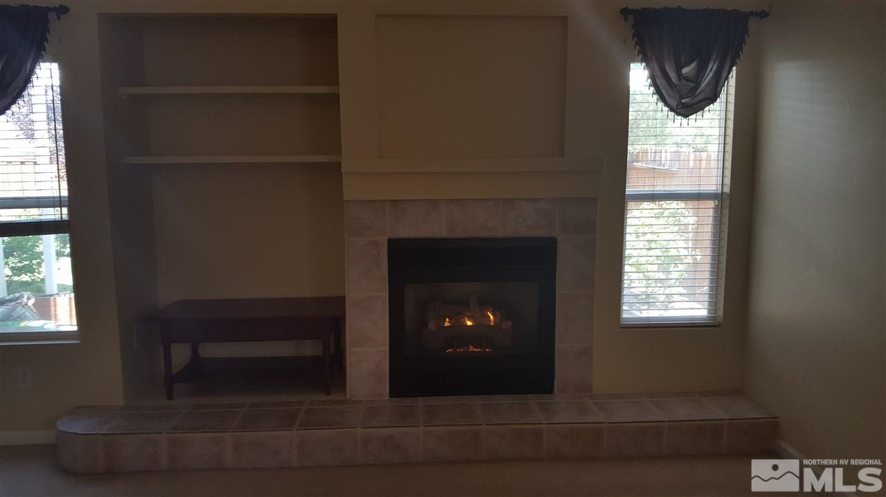 10281 Wolf Ridge Way Reno, NV 89521 - Photo 7 of 22 a living room with a fireplace and windows