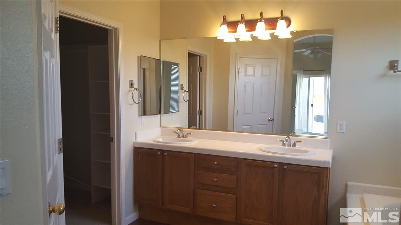 10281 Wolf Ridge Way Reno, NV 89521 - Photo 9 of 22 a bathroom with a double vanity sink and a mirror
