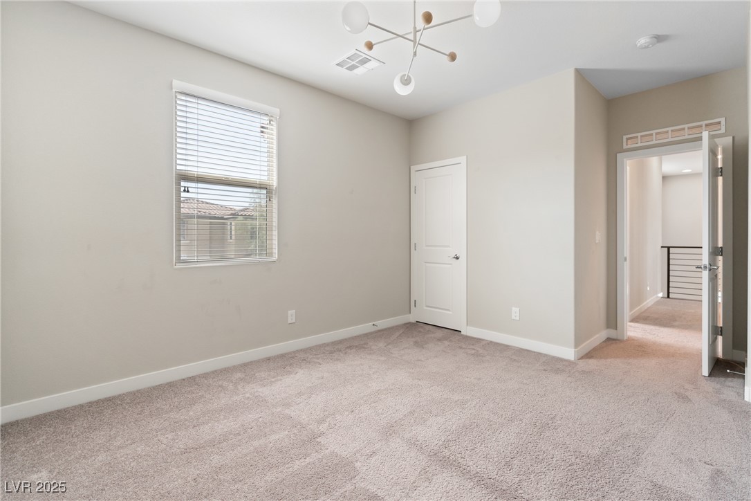 12 Papavero Court Henderson, NV 89011 - Photo 12 of 17 Unfurnished bedroom featuring light colored carpet and a chandelier