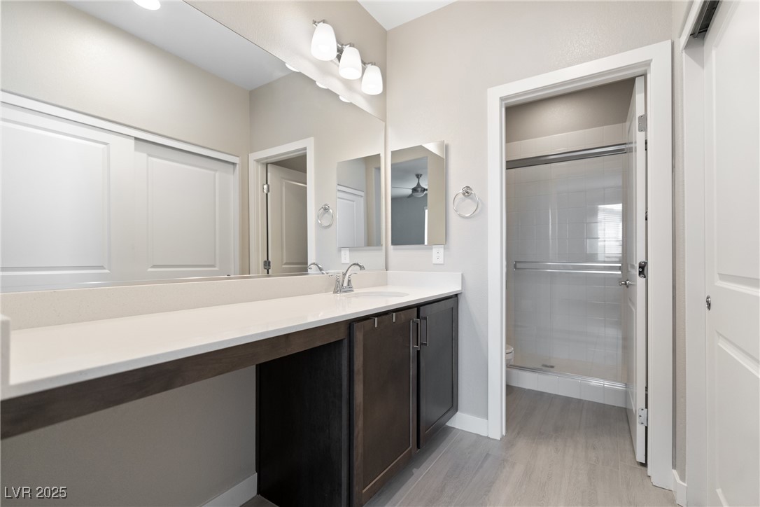 12 Papavero Court Henderson, NV 89011 - Photo 15 of 17 Bathroom with vanity, light wood-type flooring, and a shower stall