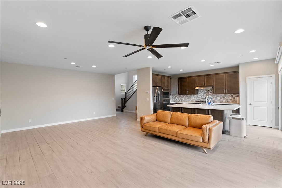 12 Papavero Court Henderson, NV 89011 - Photo 4 of 17 Living room featuring a ceiling fan, recessed lighting, light wood-style floors, and stairway