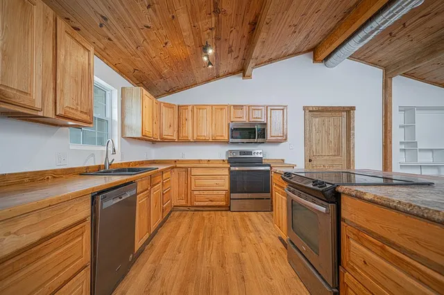 a kitchen with stainless steel appliances granite countertop a stove a sink and a refrigerator