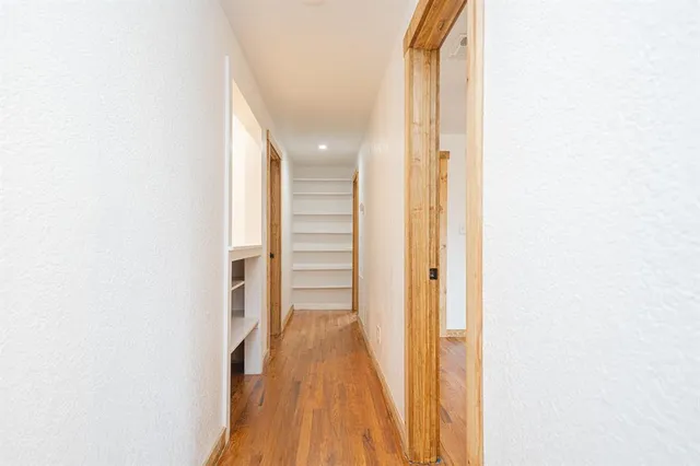 a view of a hallway with wooden floor