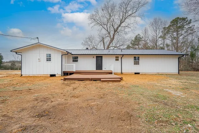 a front view of house with yard and trees in the background