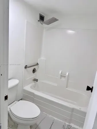 a white toilet and tub sitting next to a bathroom sink