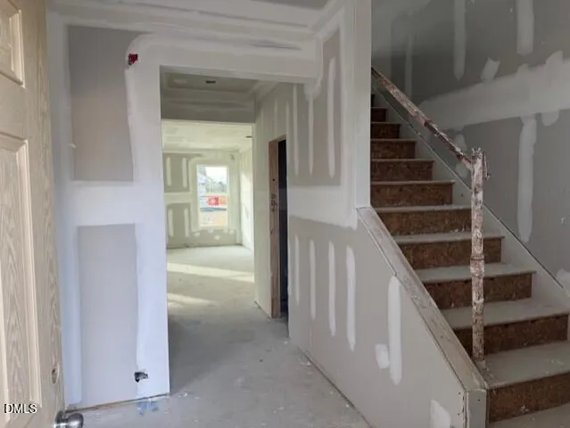a view of a hallway to an entryway with wooden floor and staircase