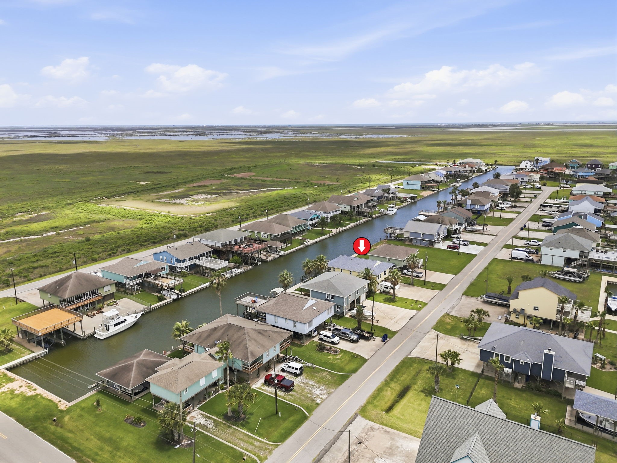 119 Sand Shoals Road Freeport, TX 77541 - Photo 2 of 34 Aerial canal corridor — direct canal-front position in Hide-A-Way on the Gulf, with deep-water boating access flowing out to the bay and protected marsh beyond.