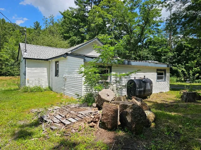 a view of backyard of house with outdoor seating and green space