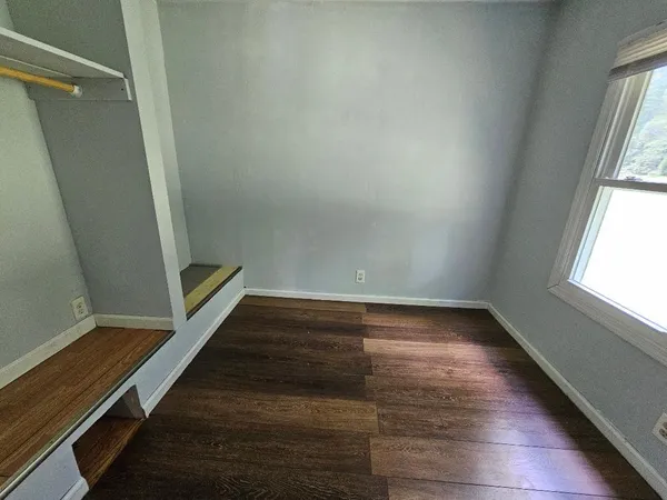 a view of a room with wooden floor and a window