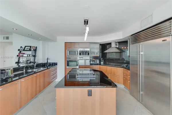 a kitchen with stainless steel appliances granite countertop a sink and a refrigerator