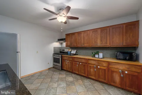 a kitchen with stainless steel appliances granite countertop a sink a stove cabinets and wooden floor