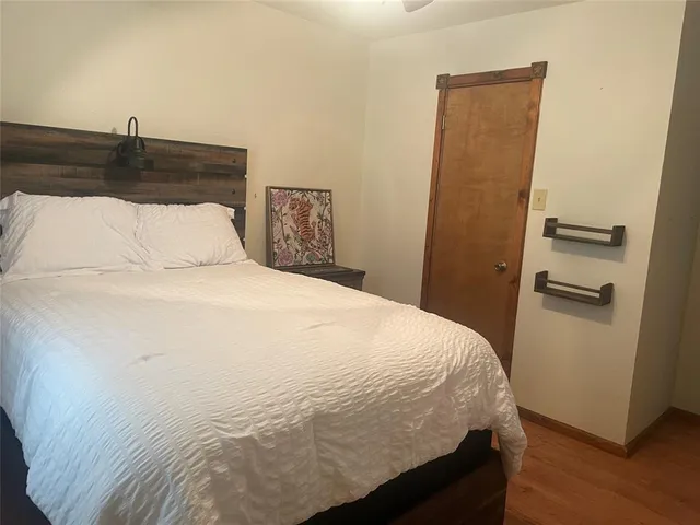 a bedroom with a bed and wooden floor