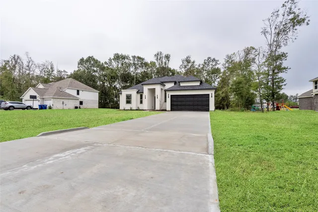 a front view of a house with a yard and trees