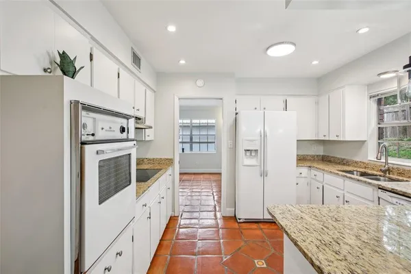a kitchen with stainless steel appliances granite countertop a refrigerator and a stove top oven