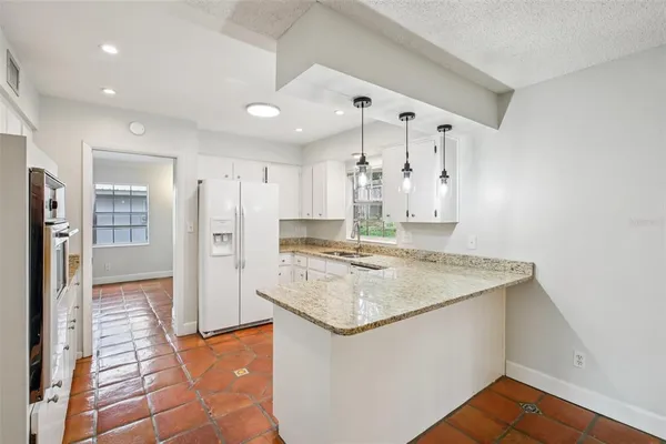 a kitchen with stainless steel appliances granite countertop a refrigerator and a sink
