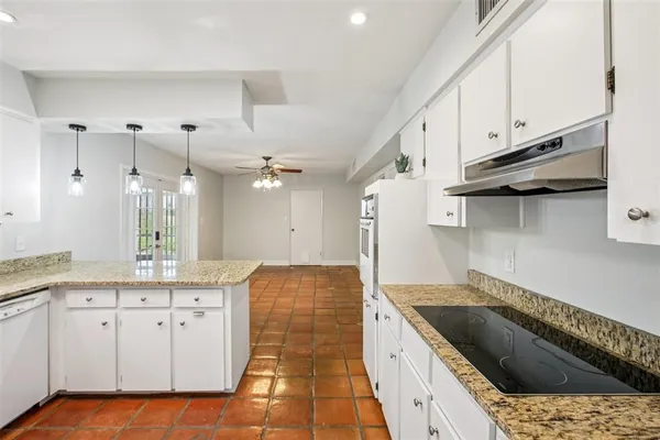 a kitchen with stainless steel appliances granite countertop a sink refrigerator and cabinets