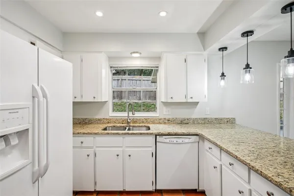 a kitchen with granite countertop white cabinets and white appliances