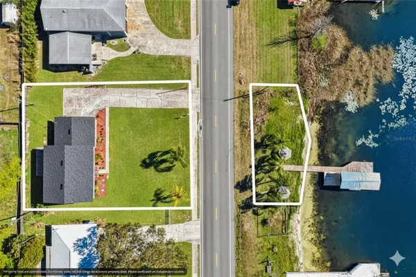 an aerial view of a residential houses with yard