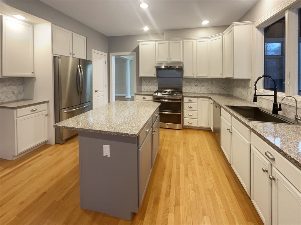 35 Peter Street Holliston, MA 01746 - Photo 2 of 38 a kitchen with kitchen island granite countertop a sink appliances cabinets and counter space