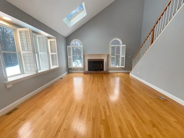 a view of a livingroom with wooden floor and a fireplace