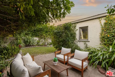 a view of a patio with couches table and chairs and potted plants